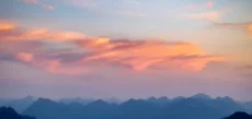 A copied photo of mountains under a pink sky